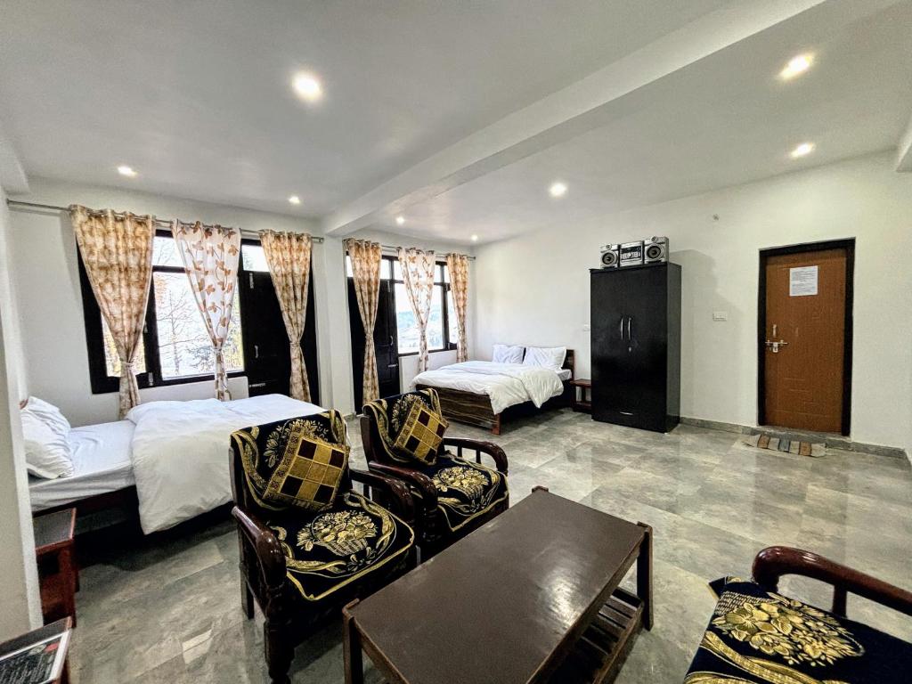 Zimmer mit 2 Betten, einem Tisch und Stühlen in der Unterkunft Tulsi Homestay in Munsyari