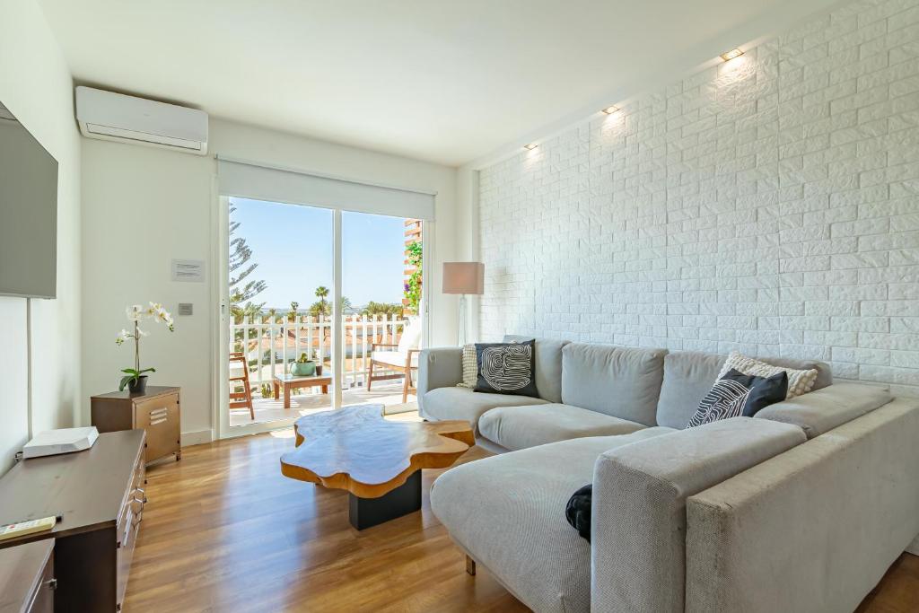a living room with a couch and a table at Luxury Loft en Maspalomas con Terraza y Piscina in Maspalomas