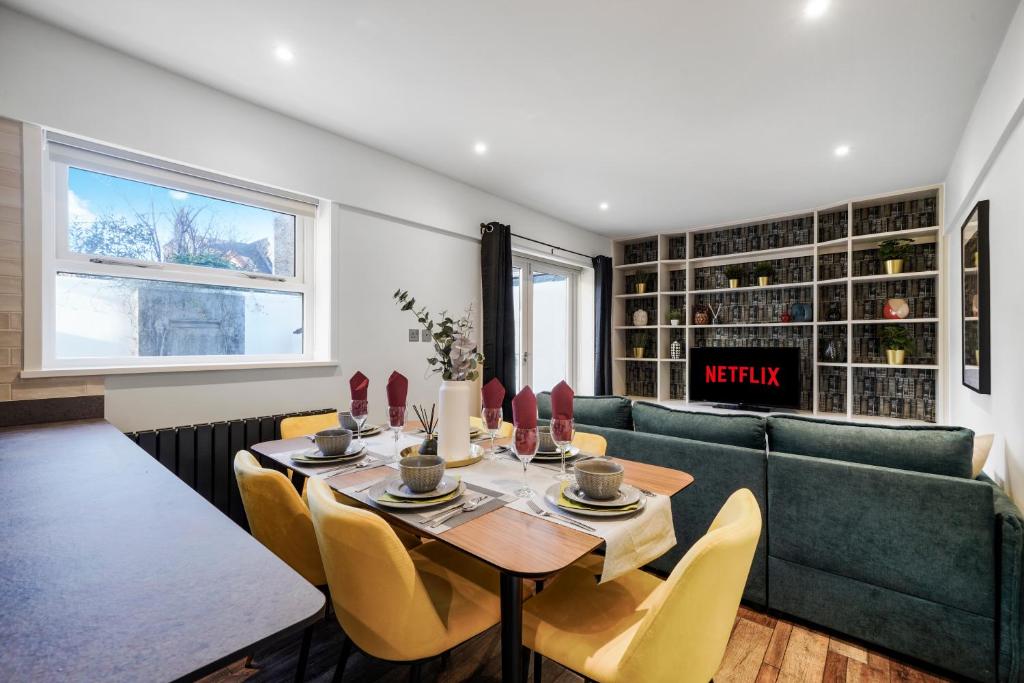 - une salle à manger avec une table et un canapé dans l'établissement Stunning Abode in London - Private Garden, à Londres
