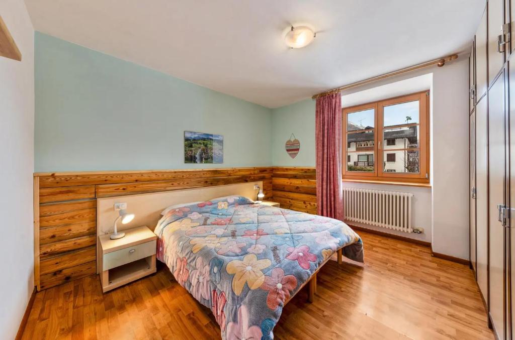 1 dormitorio con cama y ventana en Casa BlueSky - Val di Sole in Trentino, en Croviana
