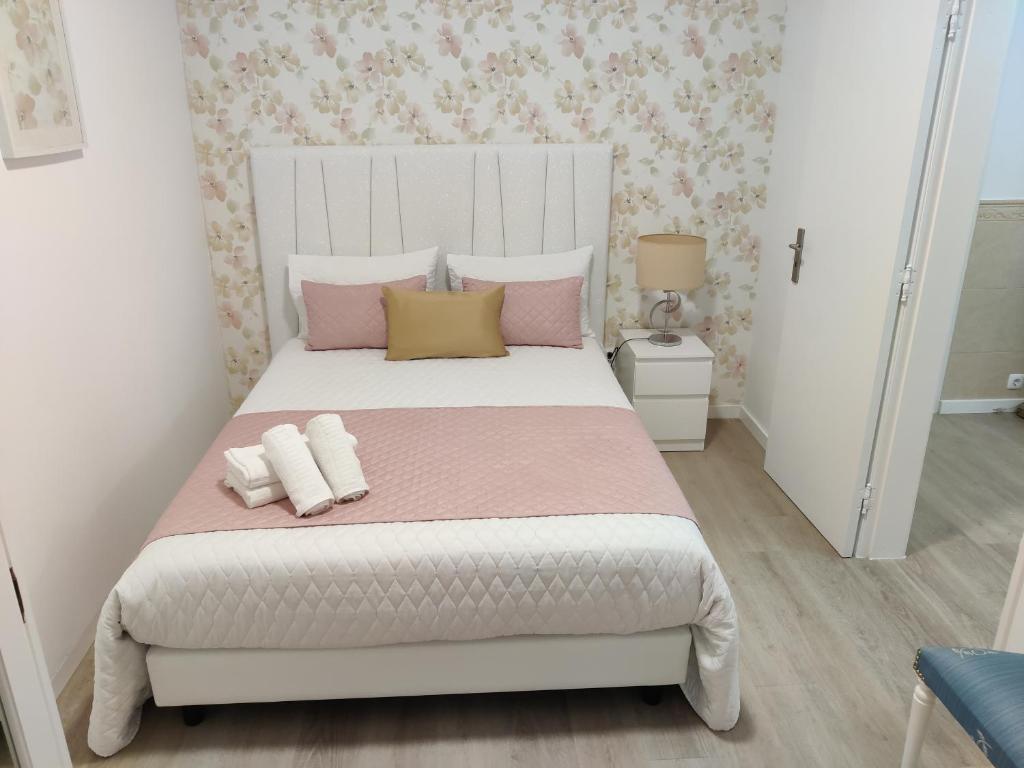 um quarto com uma cama grande com almofadas cor-de-rosa e amarelas em casa saloia na Nazaré