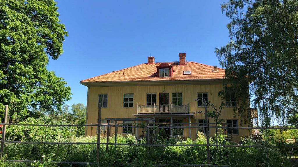 VimmerbyにあるLidhem herrgård. Bed & Breakfast och mindre lägenheterの赤屋根の大黄色い家