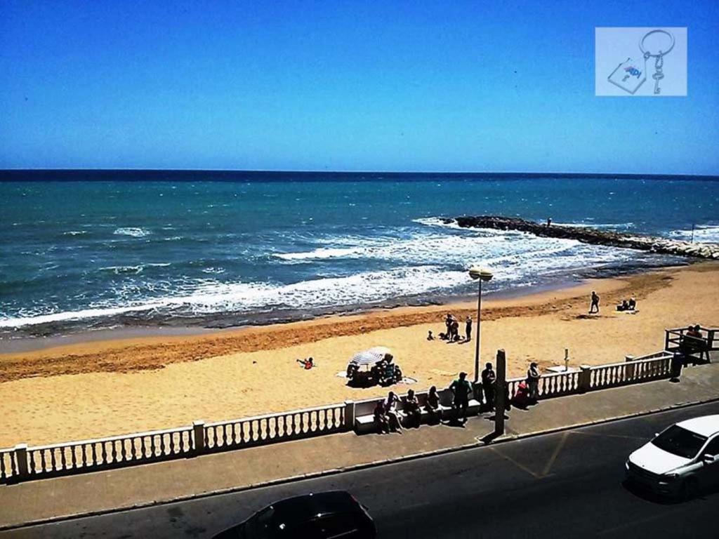 una playa con gente en la arena y el océano en Sea View Apartment, en Torrevieja