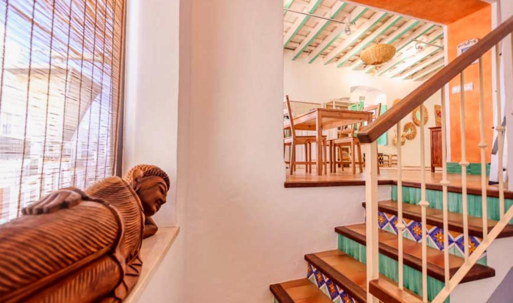 a statue sitting next to a staircase in a house at La Plaza de Conil in Conil de la Frontera