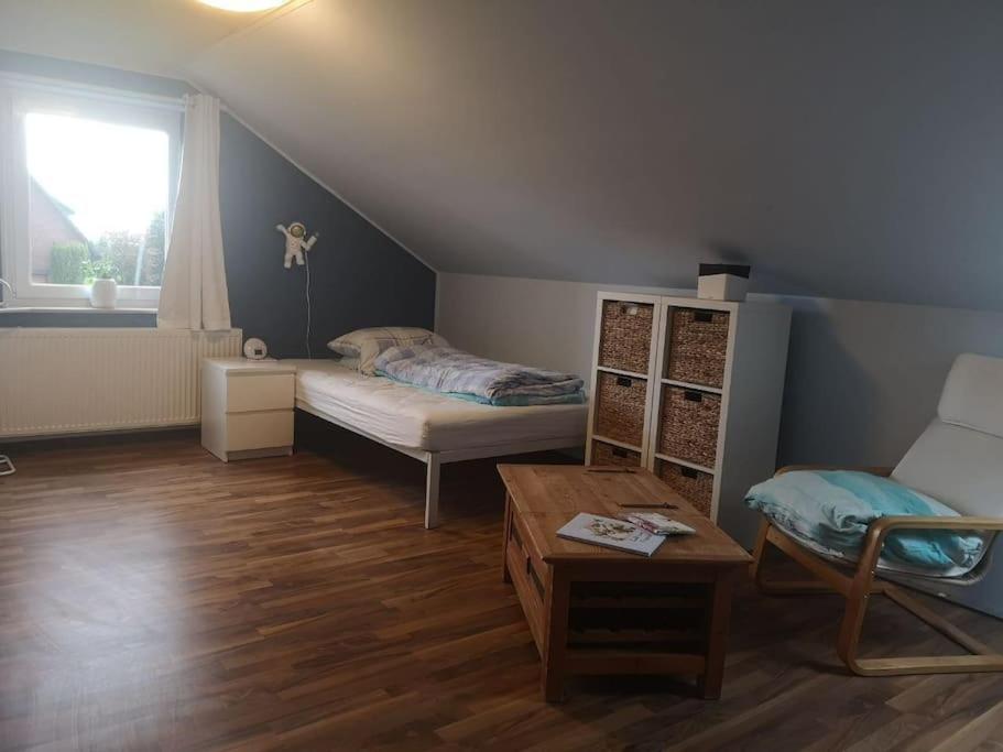 um quarto com uma cama, uma mesa e uma janela em Wohnung mit Blick aufs Blockland em Osterholz-Scharmbeck