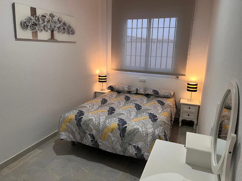 1 dormitorio con 1 cama y 1 mesa con 2 lámparas en ALFAROS HOME, en Córdoba