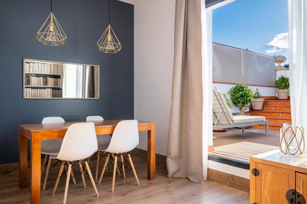 a dining room with a table and white chairs at Apartments Sixtyfour in Barcelona