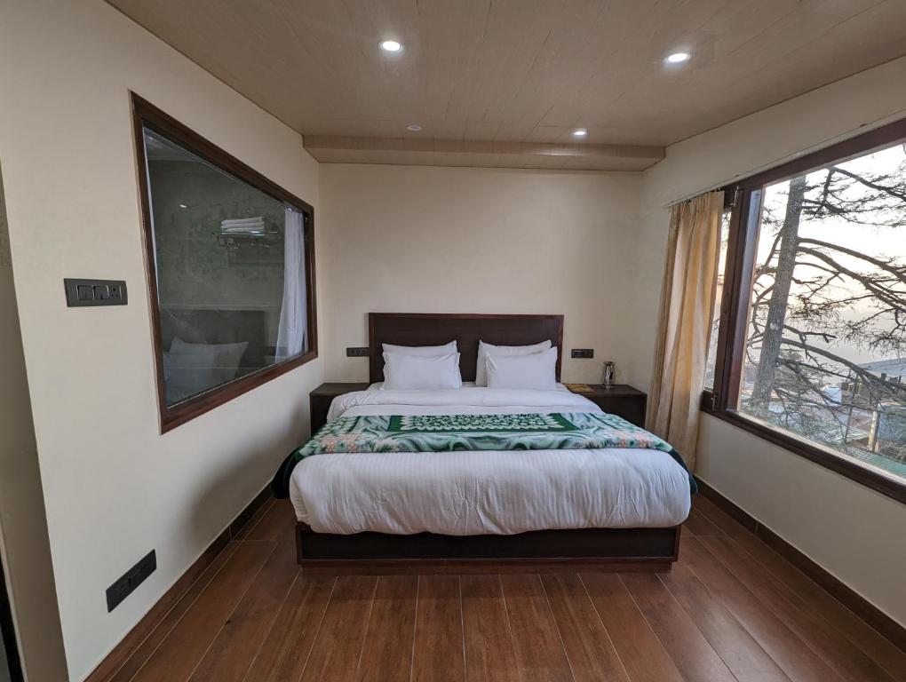 a bedroom with a bed and a large window at Summer Capital BnB in Shimla