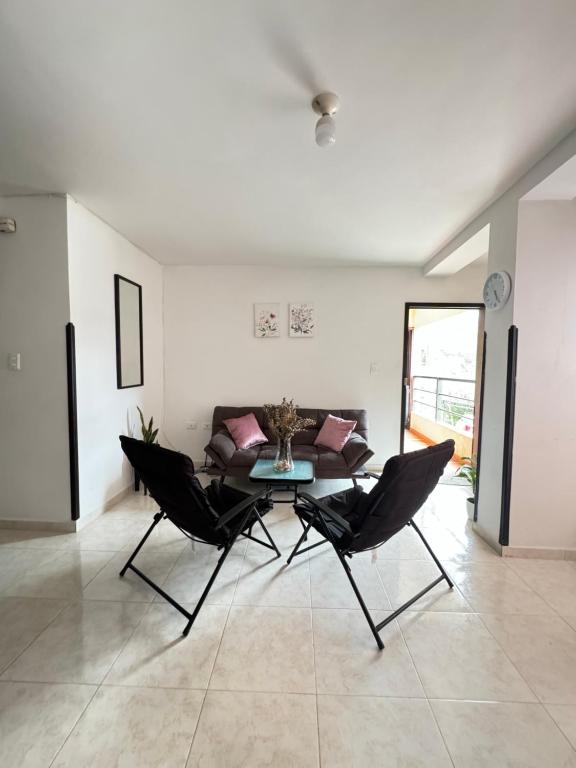 een woonkamer met een tafel en stoelen en een bank bij Apartamento amoblado para familia y amigos in San Vicente de Chucurí