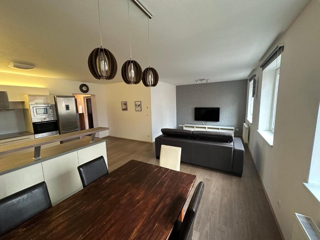 uma cozinha e sala de estar com uma mesa e um sofá em City Center apartment FREE PRIVATE PARKING em České Budějovice