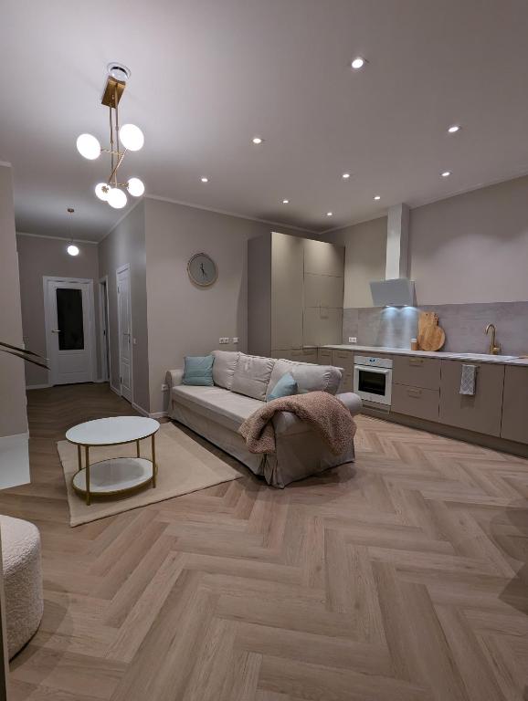 a living room with a couch and a table at Mere Apartment - Private Yard, Sauna and Pet Friendly in Pärnu