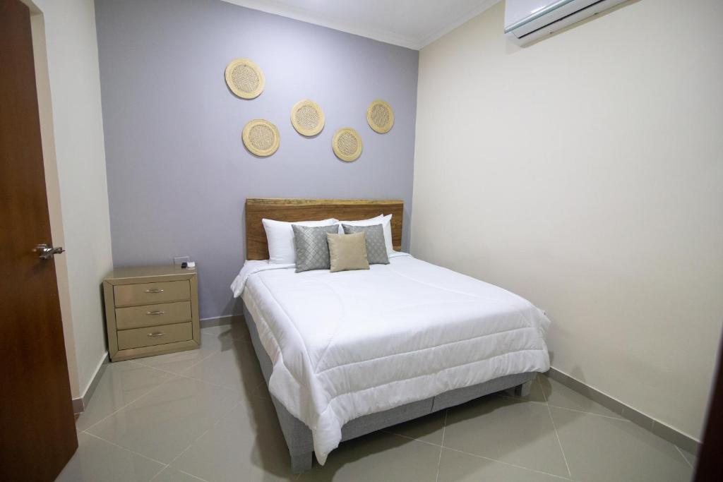 a bedroom with a bed and three plates on the wall at Casa Palmar Cartagena in Cartagena de Indias