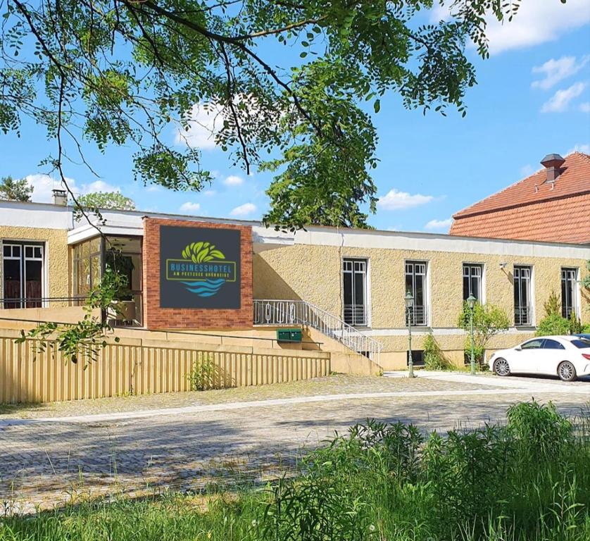 un edificio con un cartel en el costado en BusinessHotel Am Peetzsee Grünheide, 