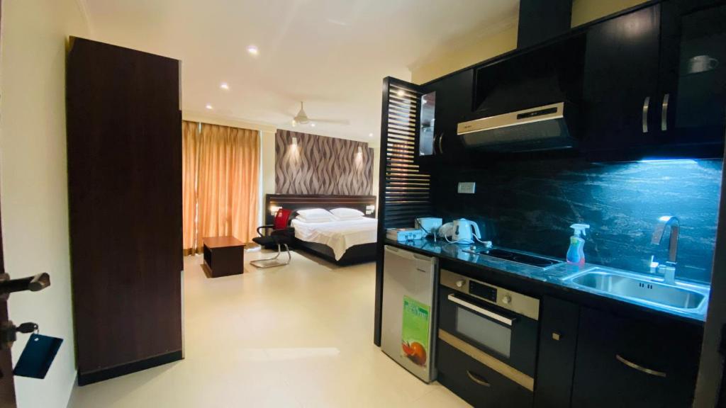 a kitchen with a sink and a bed in a room at Splendid Holiday Guest House in Negombo