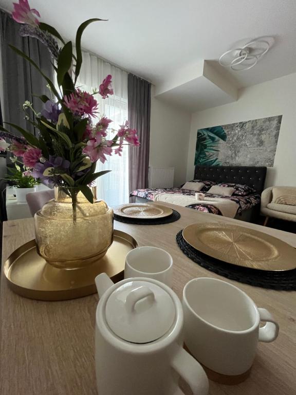 una sala de estar con una mesa con un jarrón de flores en Apartament Nova Klonova en Kielce