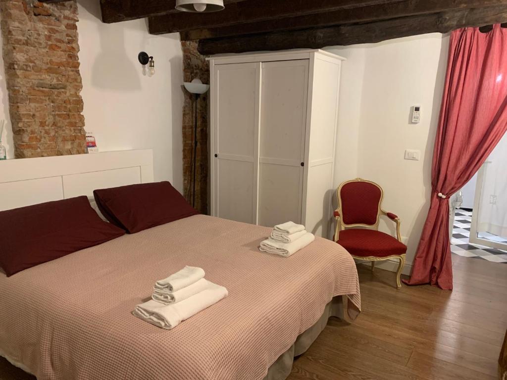 1 dormitorio con 1 cama con toallas en CASA CIMELLA, un nido nel cuore del porto antico cod CITRA 010025-LT-2629, en Génova