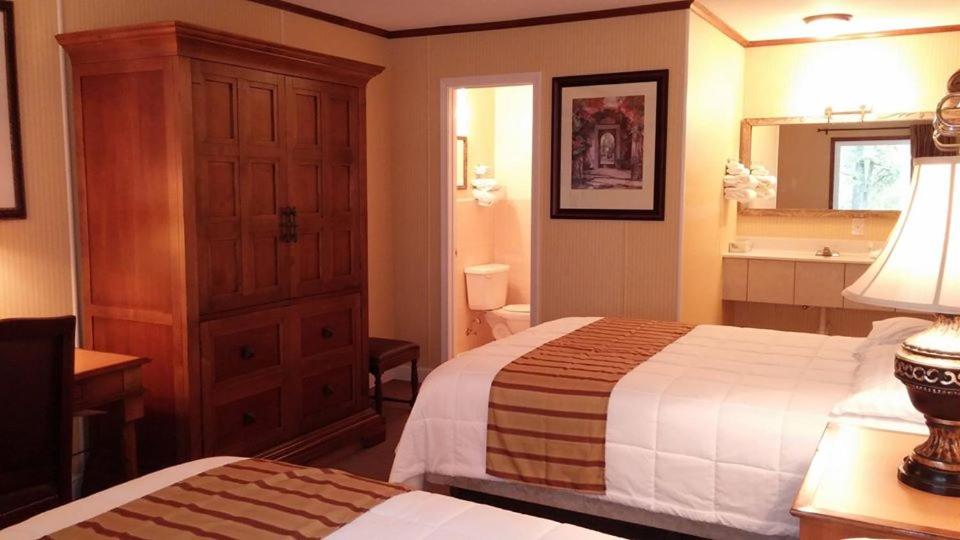 a hotel room with two beds and a bathroom at Southern Comfort Inn & Resort in Fairfield Bay