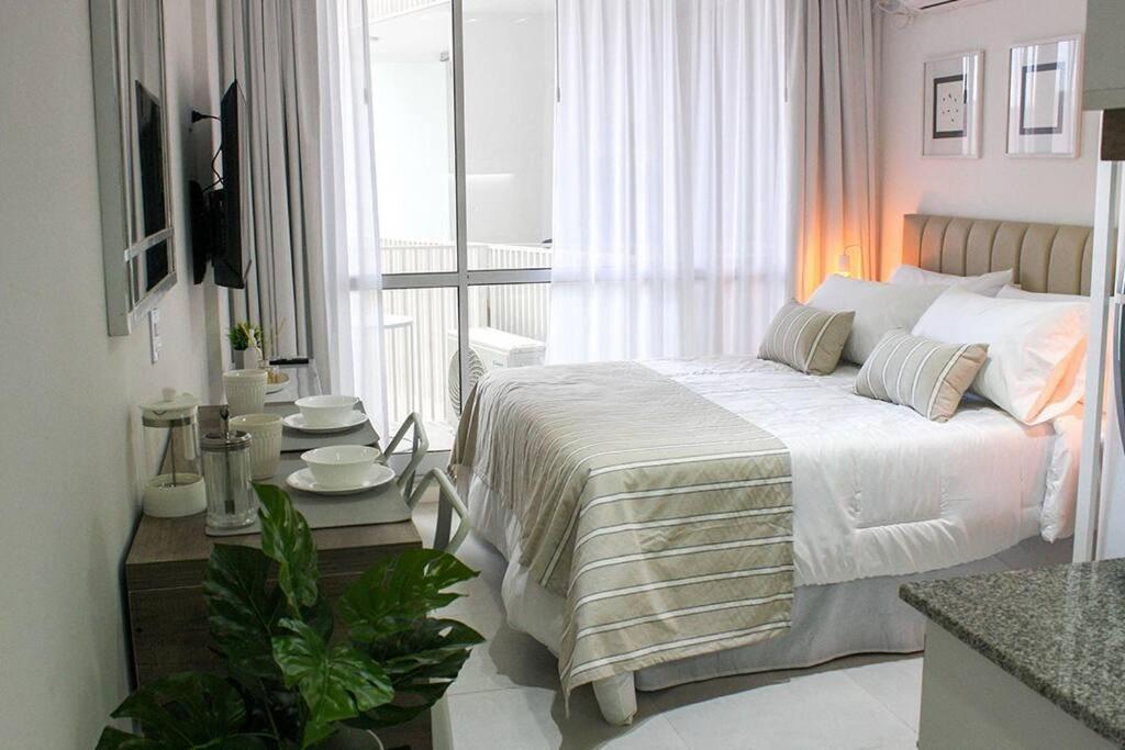 a white bedroom with a bed and a balcony at BOLI 0613 San Telmo Charm: Monoambiente Cozy in Buenos Aires