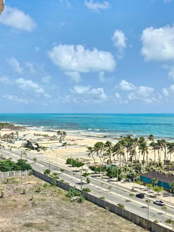 a view of the beach from the balcony of a resort at Apartamento Beach Village Praia do Futuro by WL Temporada in Fortaleza