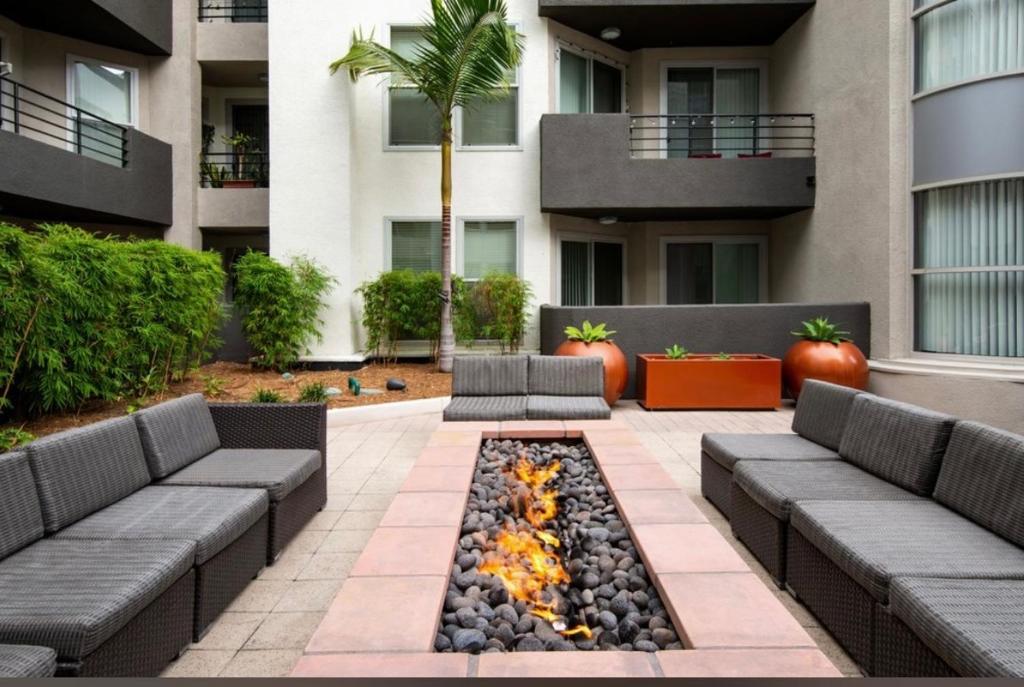a patio with two couches and a fire pit in front of a building at Spacious and Central with a Pool View in Los Angeles