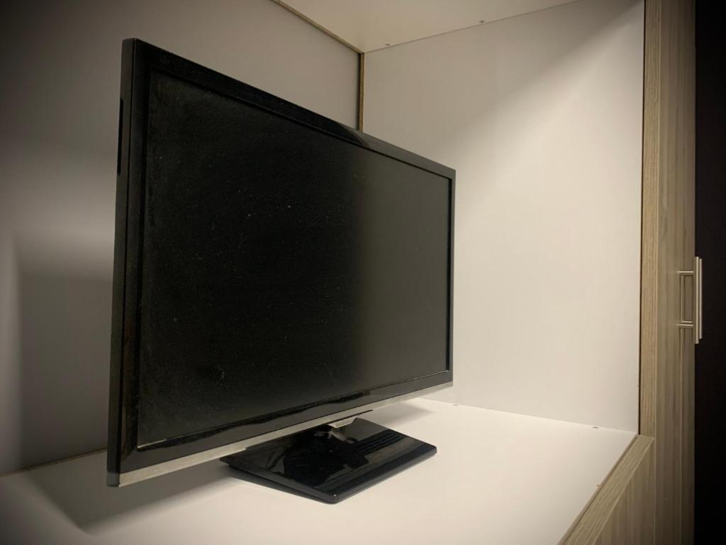 una TV a schermo piatto seduta sopra un tavolo di Joannas Luxury Room a Artemida