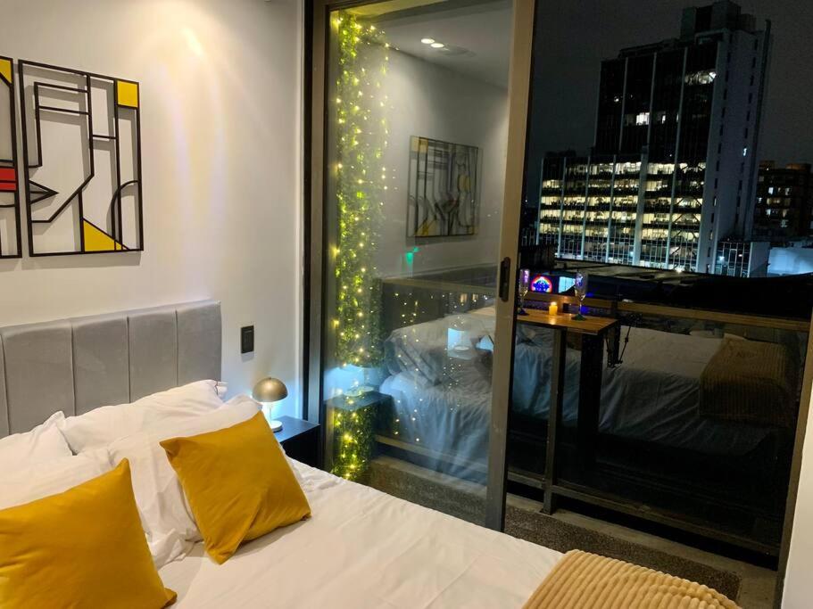 sypialnia z łóżkiem i widokiem na miasto w obiekcie Apartaestudio súper ubicado w mieście Bogota
