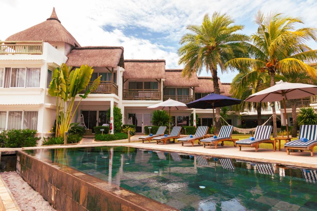 un complexe doté d'une piscine avec des chaises longues et des parasols dans l'établissement Seapoint Boutique Hotel, à Pointe aux Cannoniers