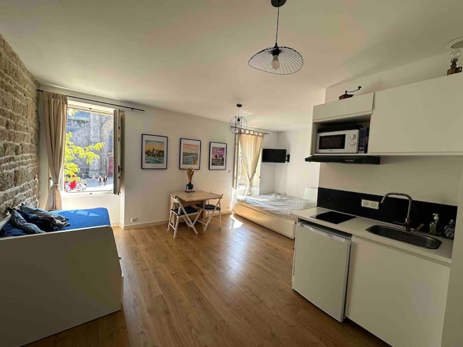 une pièce avec une cuisine et un salon dans l'établissement Guérande, studio entier intra-muros, à Guérande