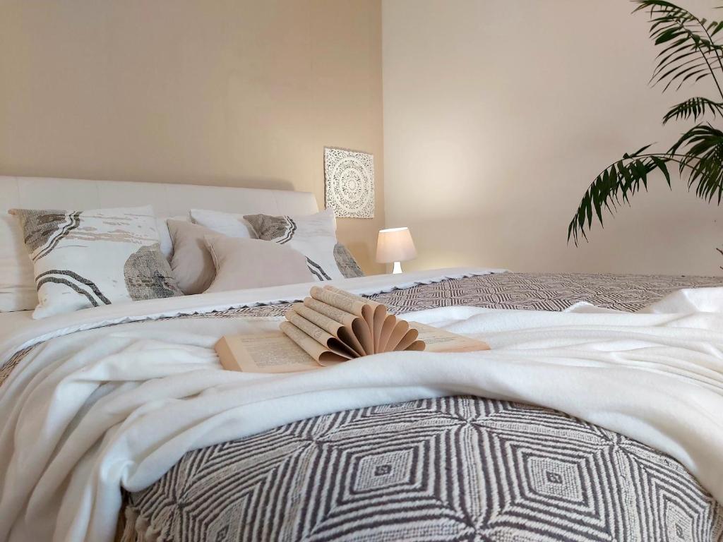 a bedroom with a bed with a book on it at Léna Apartman - Eger in Eger