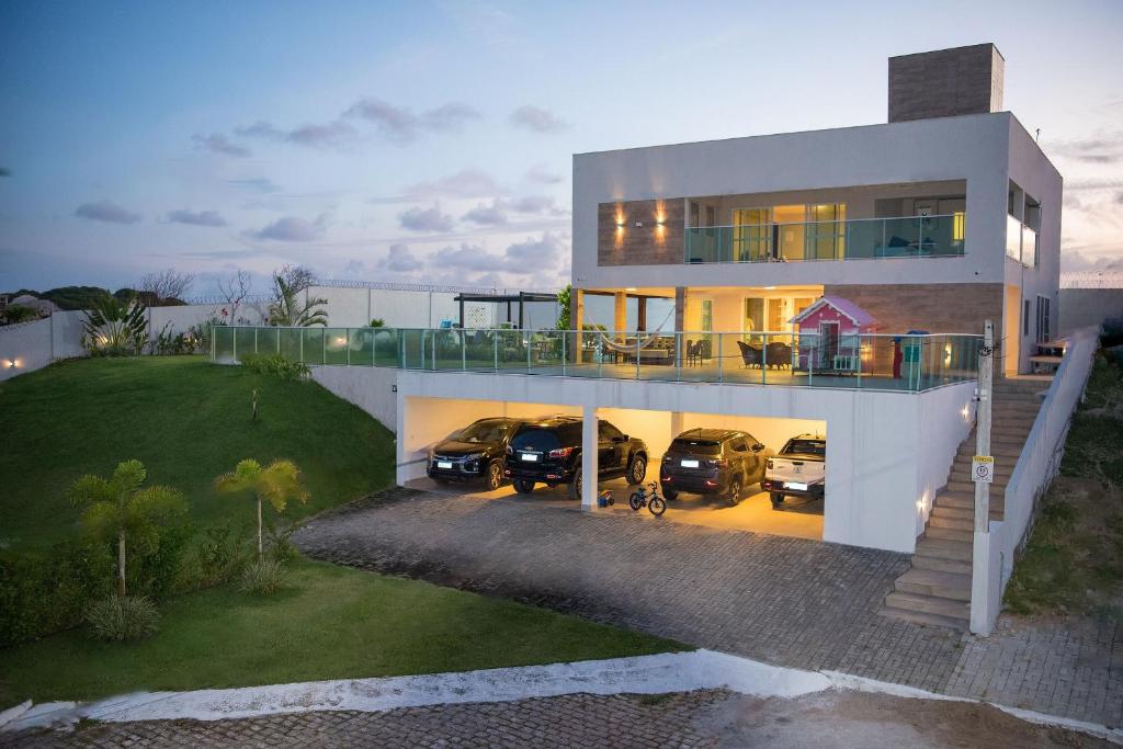 a large house with cars parked in a driveway at Casa Espetacular na Praia de Graçandu by Carpediem in Extremóz