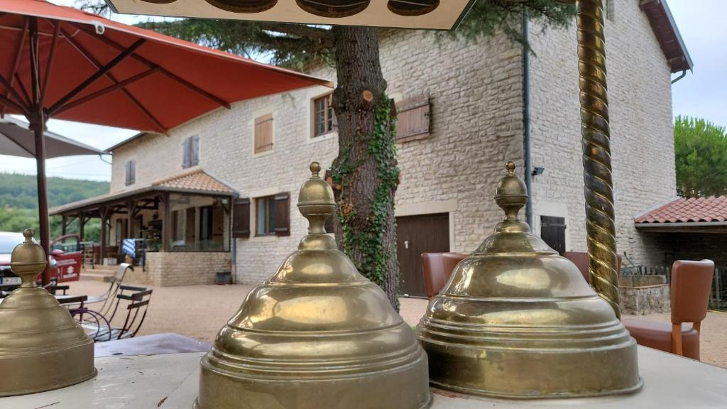 deux cloches assises sur une table devant un bâtiment dans l'établissement Domaine Bassy, à Saint-Gengoux-de-Scissé