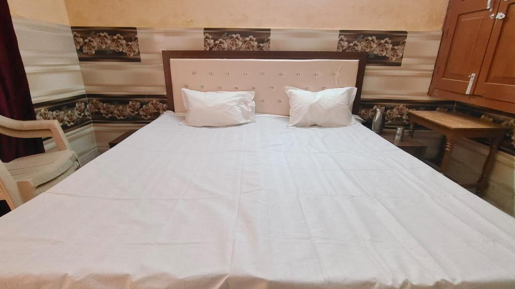 1 cama blanca grande con 2 almohadas en Shree Narayan Home Stay, en Ayodhya