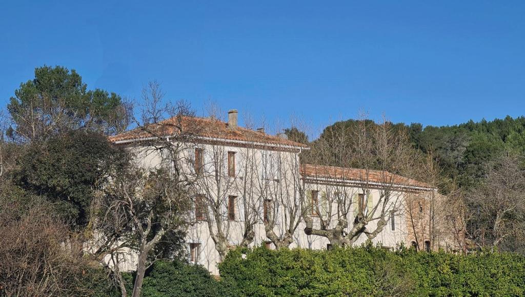 un vecchio edificio in cima a una collina con alberi di Studio Vintage dans la nature a Carnoules