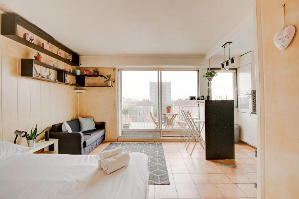 sala de estar con sofá y cocina en Elegant apartment in Le Pré-Saint-Gervais, en Le Pré-Saint-Gervais