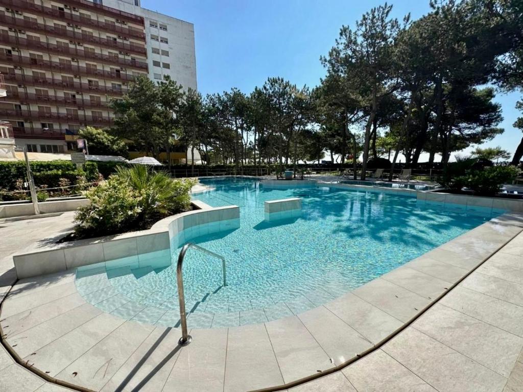 ein großer Pool mit blauem Wasser in einer Stadt in der Unterkunft SeaView Fish2 in Lignano Sabbiadoro