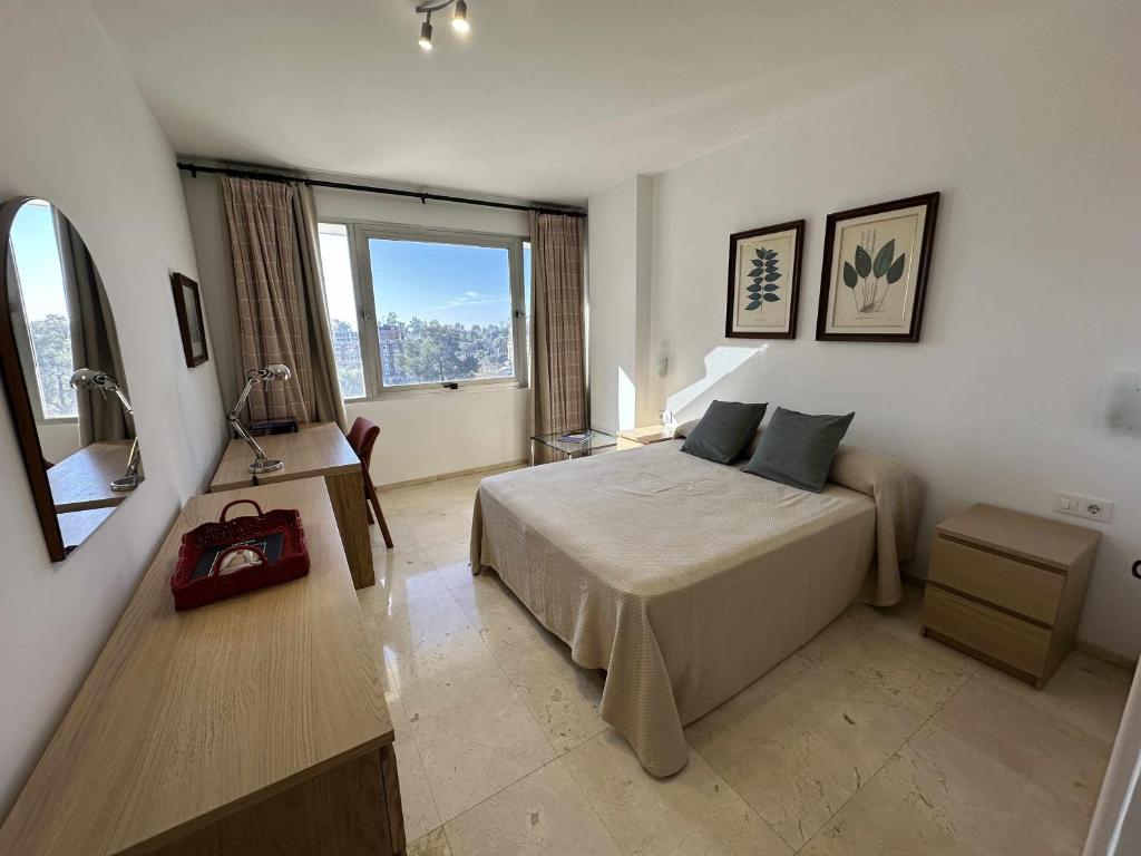 een slaapkamer met een bed en een groot raam bij Estupendo apartamento junto a Plaza de España in Sevilla