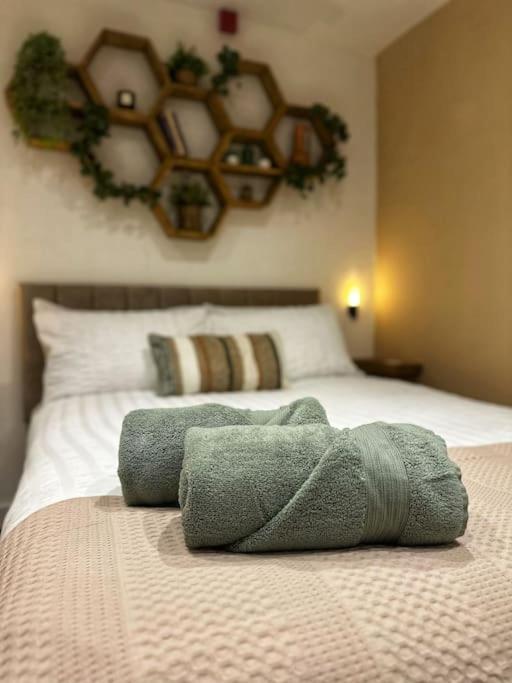 uma cama com duas toalhas em cima em The Hive - Cosy Studio in Wells City Centre em Wells