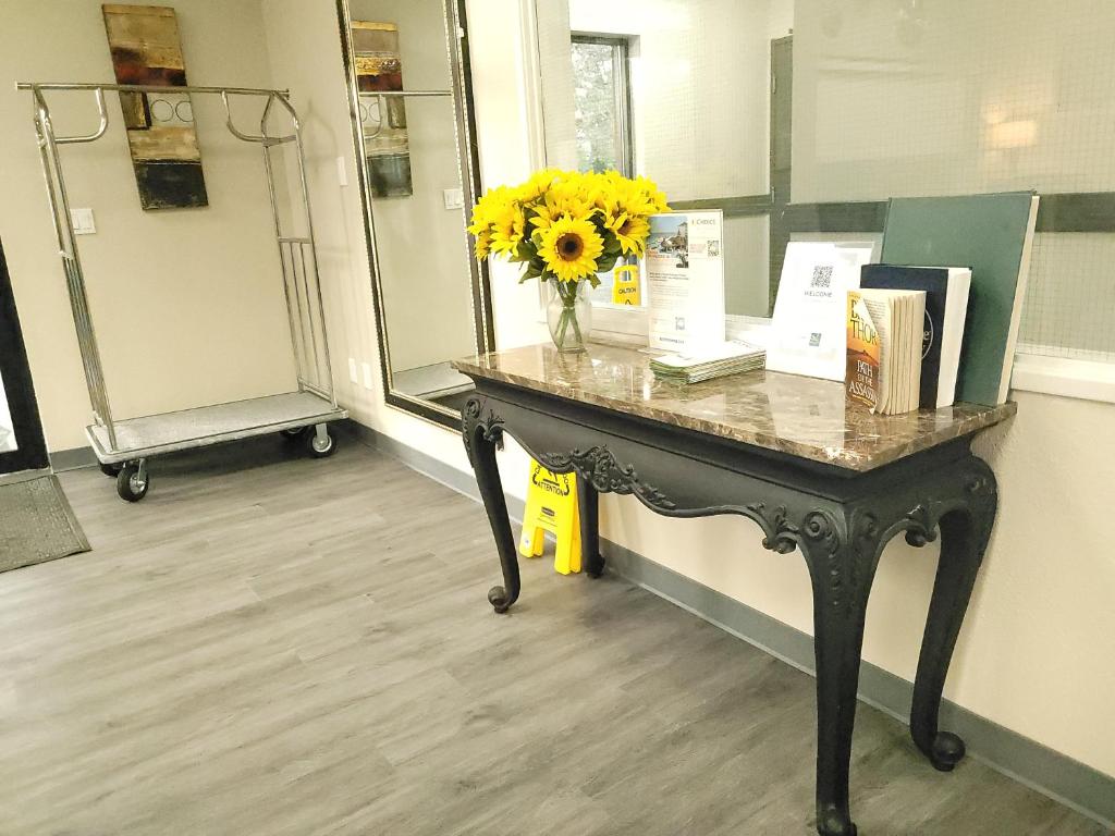 a table with a vase with a yellow flower on it at Quality Inn & Suites Wilsonville in Wilsonville