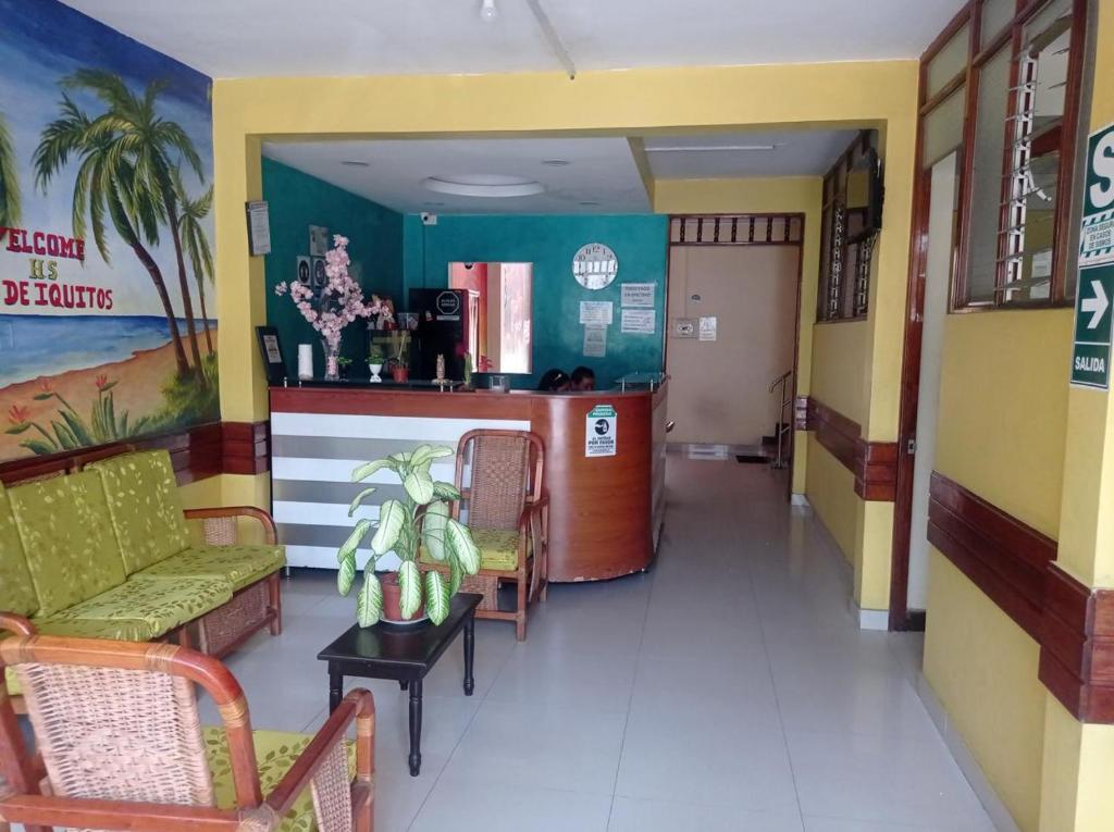 uma sala de espera com um sofá, uma mesa e cadeiras em LA CASA DEL ENCANTO em Iquitos
