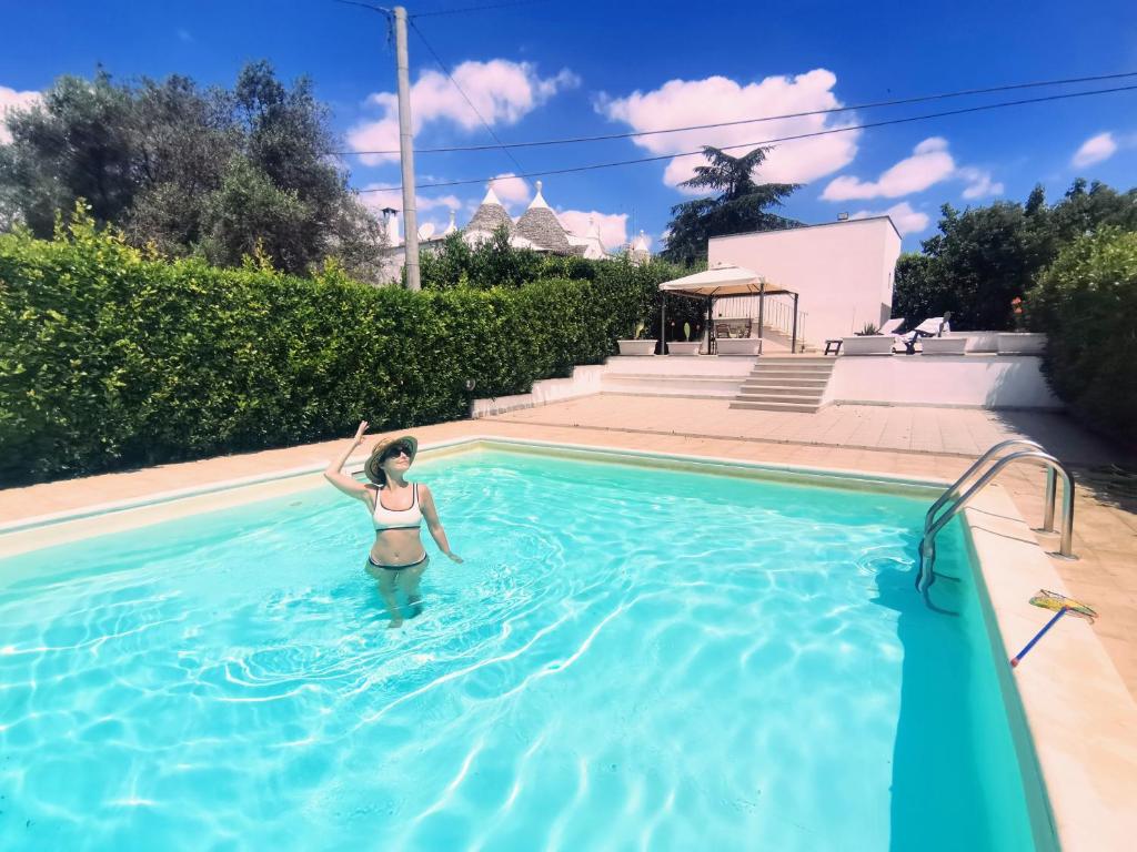 una mujer está parada en una piscina en Trulli and Pool - I Cactus, en Martina Franca