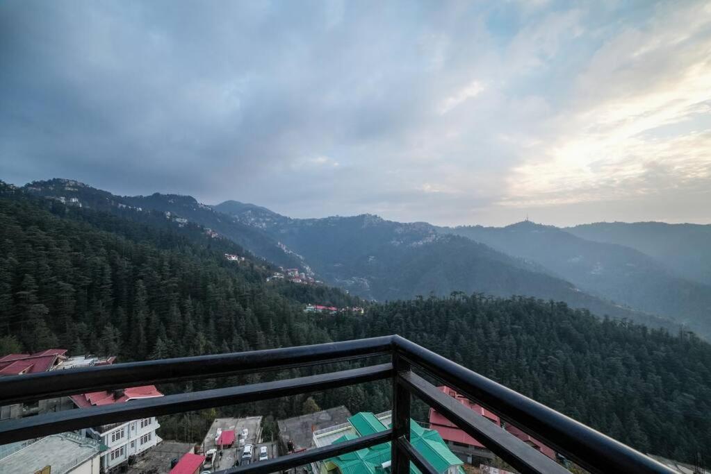 een balkon met uitzicht op de bergen bij Mom Blessing Homestay in Shimla