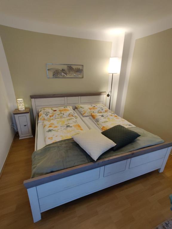 ein großes Bett in einem Schlafzimmer mit einer Lampe in der Unterkunft Appartements-Ella in Wien