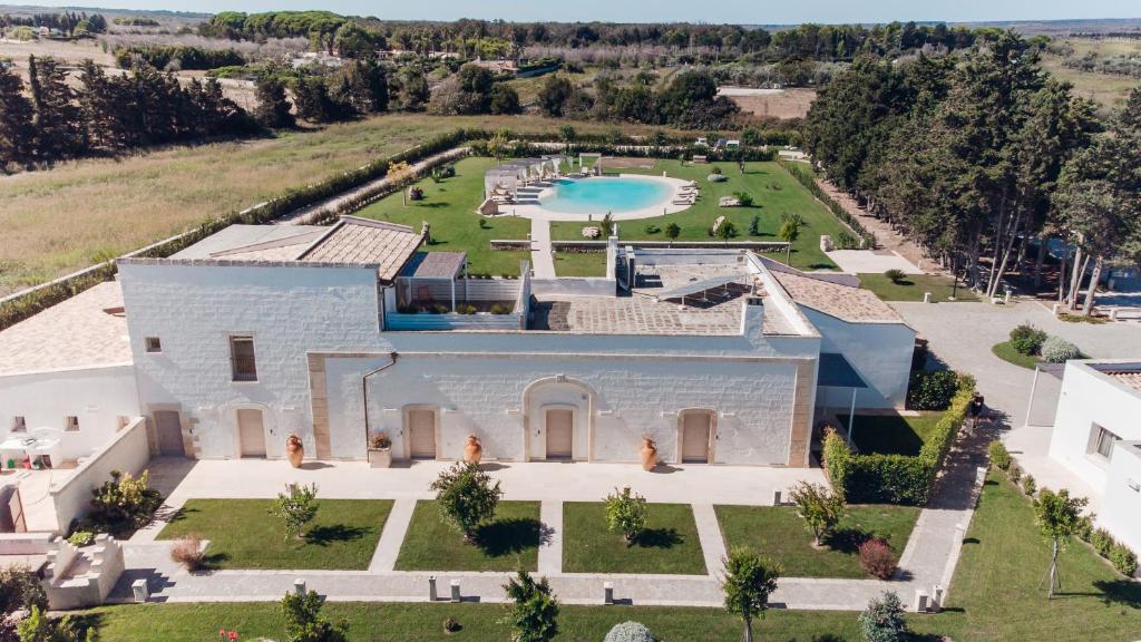 an aerial view of a large white house with a pool at Masseria Longa Boutique Hotel in Otranto
