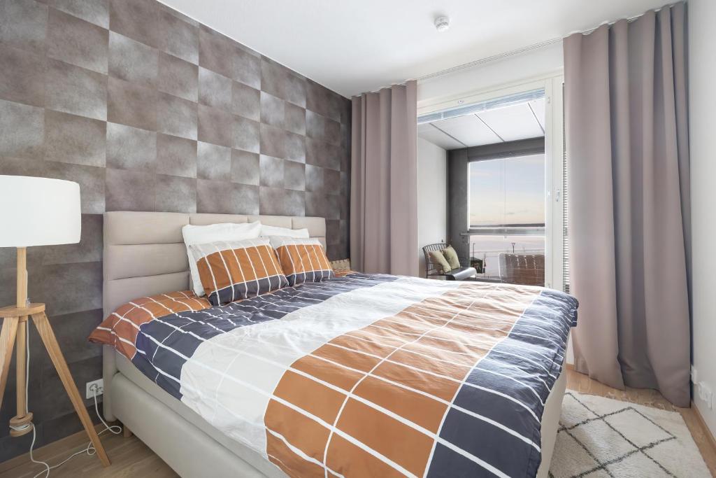 Un dormitorio con una cama grande y una ventana en Top, cozy, lakeside, sauna and free indoor parking, en Tampere