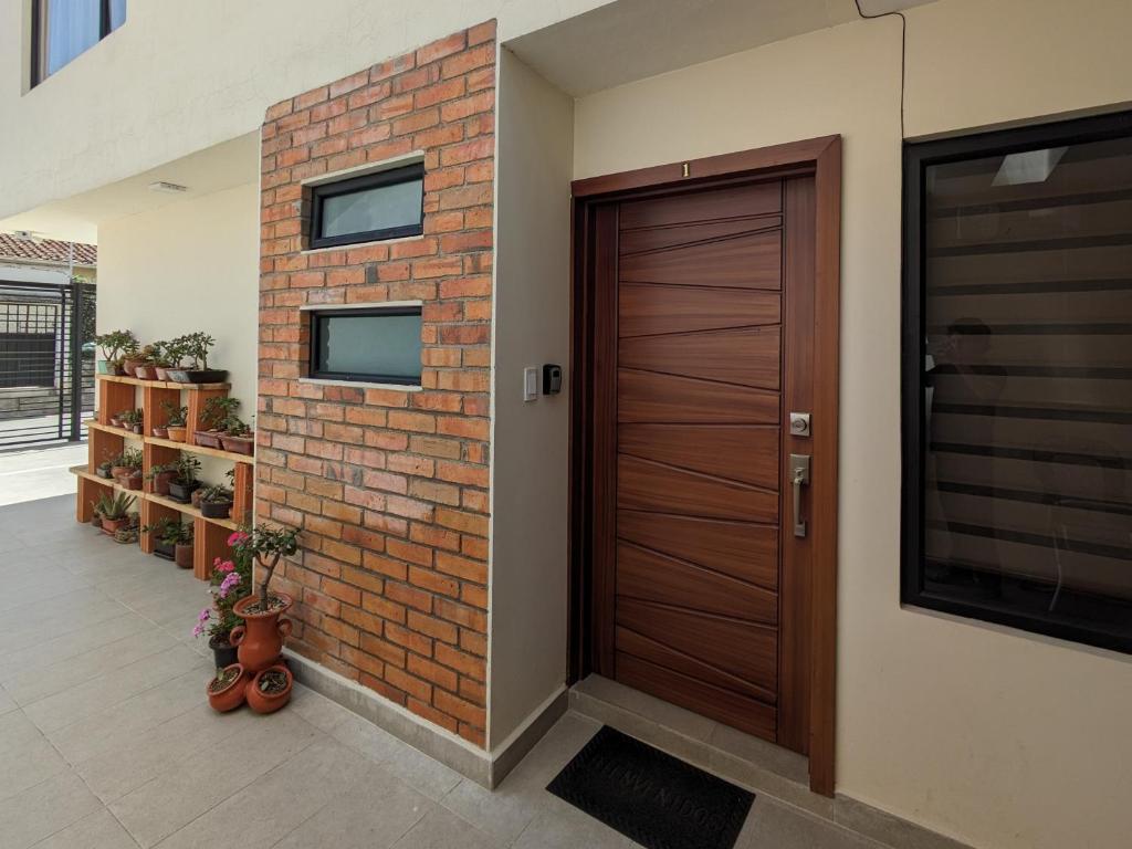 a wooden door in a room with a brick wall at Casa Crema in Cuenca