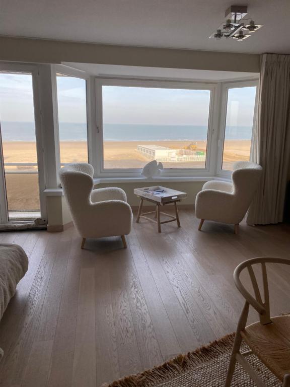 salon z krzesłami i widokiem na ocean w obiekcie Cocotte au zoute w mieście Knokke-Heist