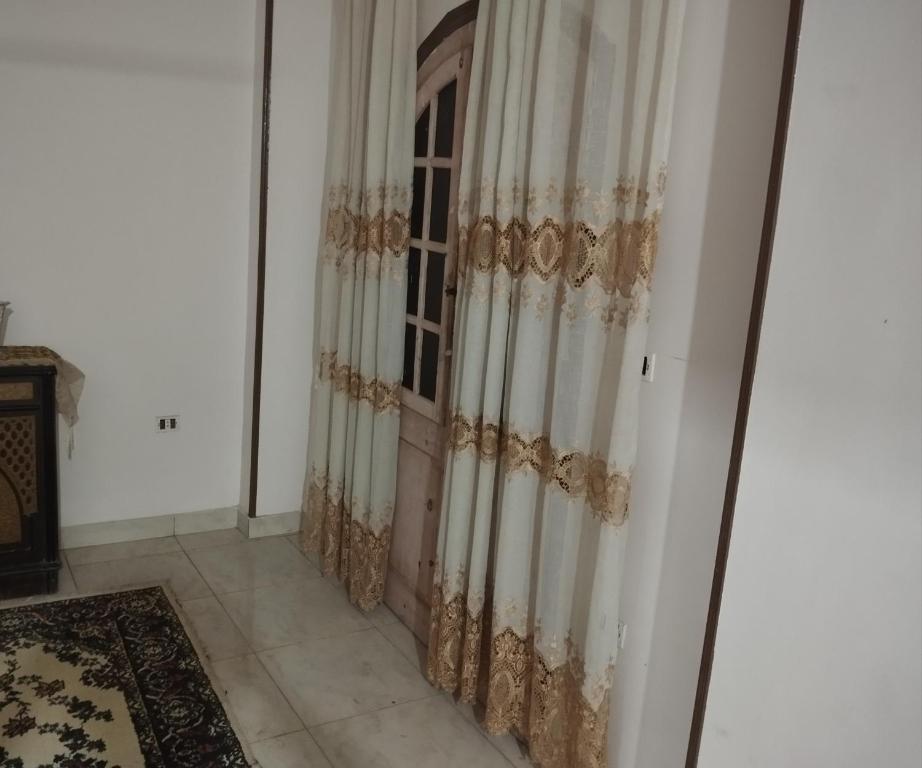ein Zimmer mit einem Fenster mit Vorhängen darauf in der Unterkunft شقة in Aţ Ţarfāyah