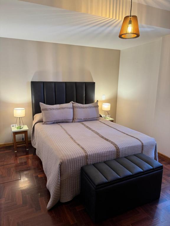 DEPARTAMENTO Céntrico MENDOZA في ميندوزا: غرفة نوم مع سرير كبير مع اللوح الأمامي الأسود