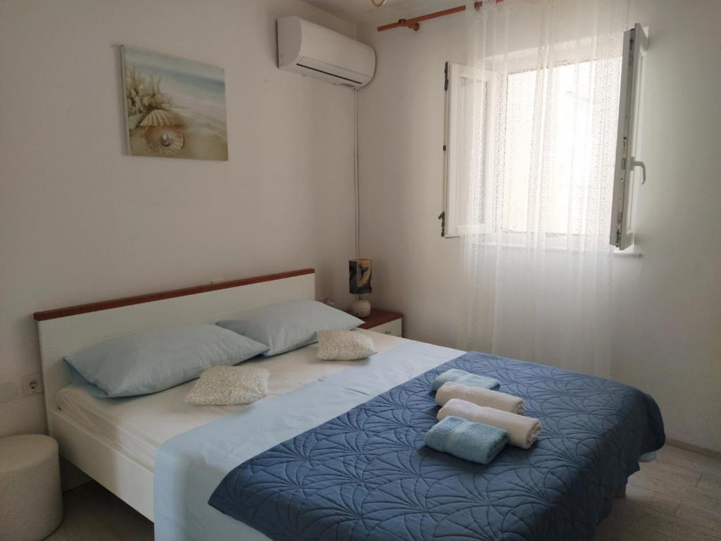 a bedroom with a bed with towels on it at Rooms & studio OLD TOWN PAG in Pag