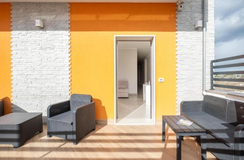 una sala de estar con una pared amarilla y blanca en B&B - Over the top - Affittacamere, en Copertino